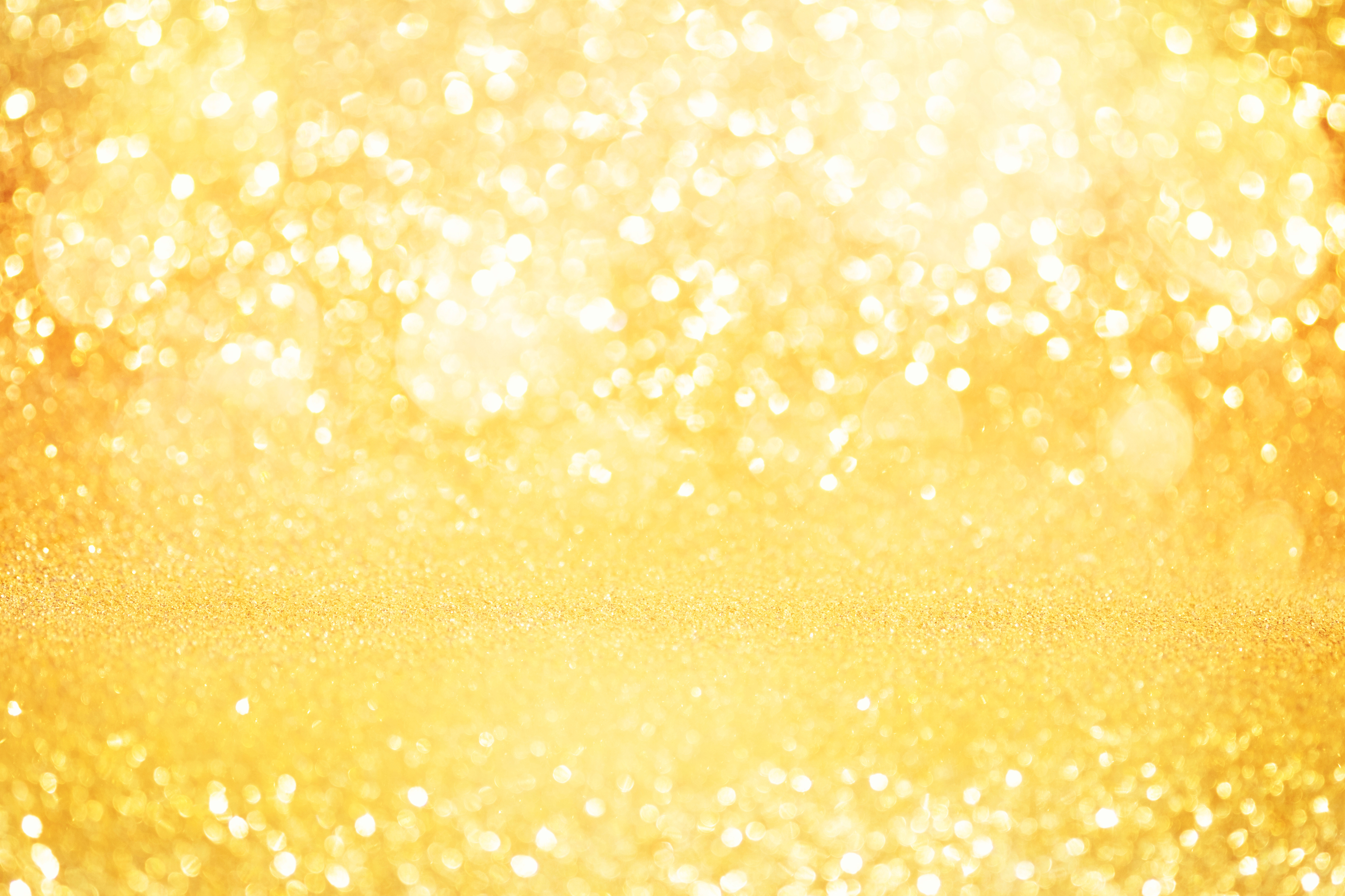 Abstract gold glitter bokeh lights with soft light background.